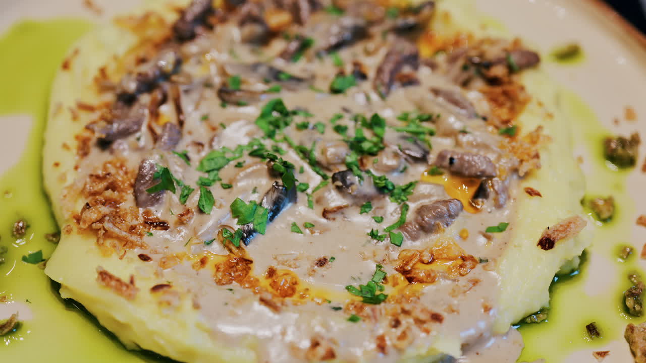 Close up of a creamy mushroom sauce over mashed potatoes on a plate at a restaurant