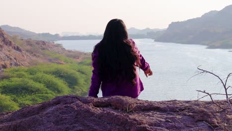 Niña-Aislada-En-La-Cima-De-La-Montaña-Con-Vista-Al-Lago-Backbit-Tomada-Desde-Un-ángulo-Plano-Video-Tomado-En-El-Lago-Kaylana-Jodhpur-Rajasthan-India