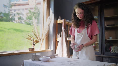 mujer moldeando arcilla en el estudio de cerámica