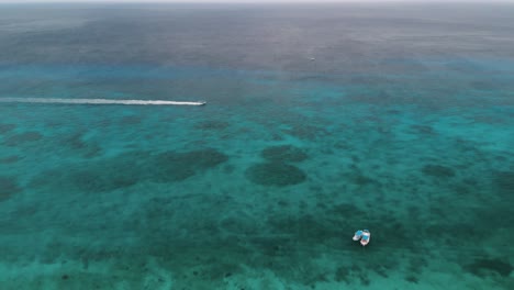 Lancha-A-Toda-Velocidad-A-Través-Del-Mar-Tropical-Cerca-De-La-Playa-En-México,-Panorámica-A-La-Derecha