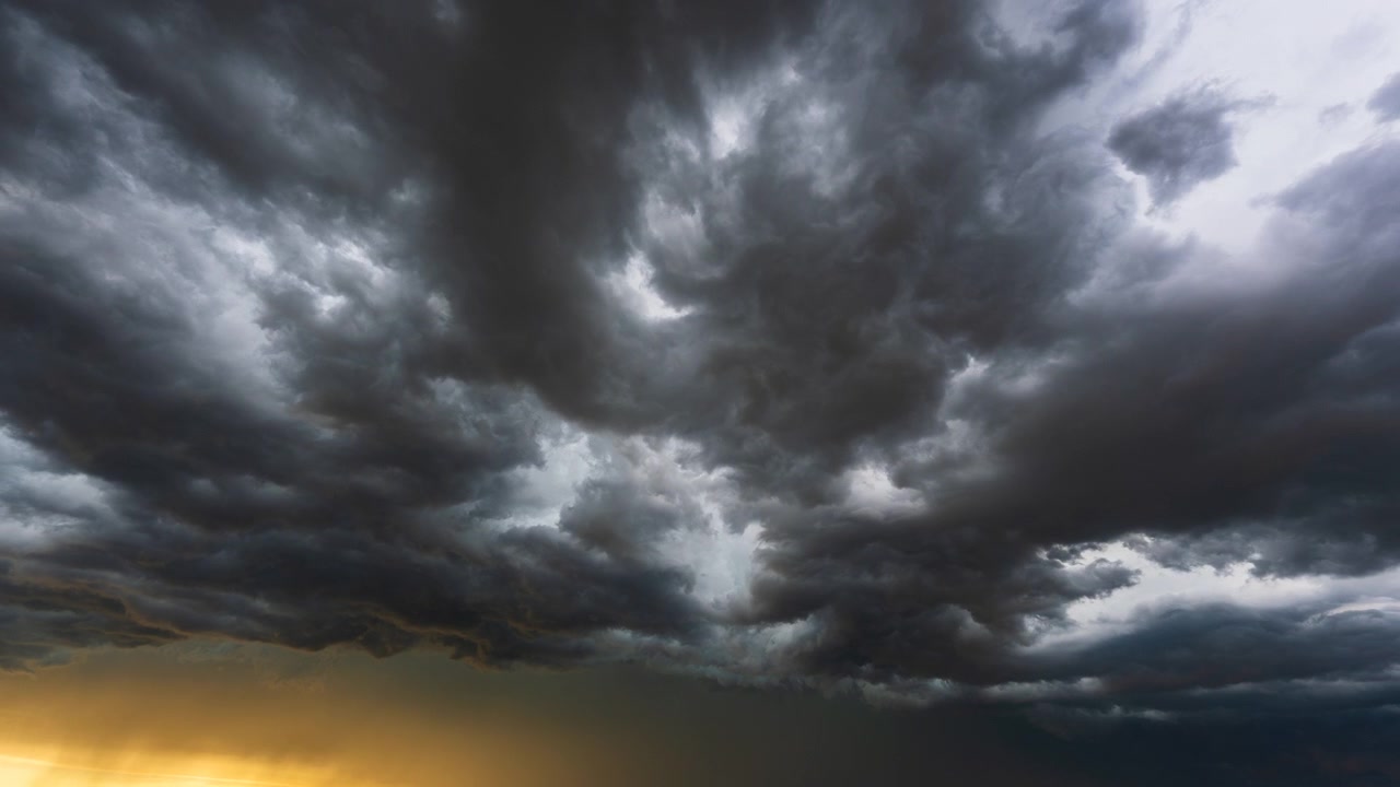 Dark cumulonimbus storm clouds swirling in intense weather sky scene