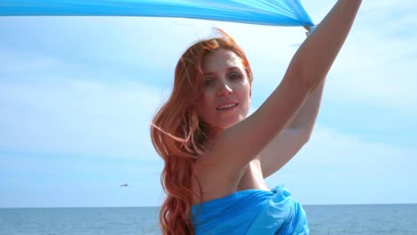 sensual woman with blue cloth flying on wind. woman portrait. redhead women