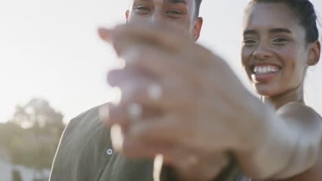 Happy-diverse-bride-and-groom-laughing-and-showing-wedding-rings-at-beach-wedding,-in-slow-motion