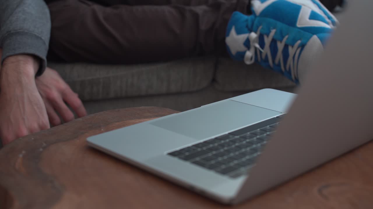 피곤한 사람이 노트북에 입력한 다음 다시 소파에 누워