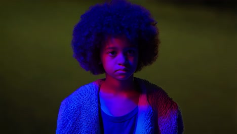 retrato de una joven con cabello afro en una iluminación vibrante