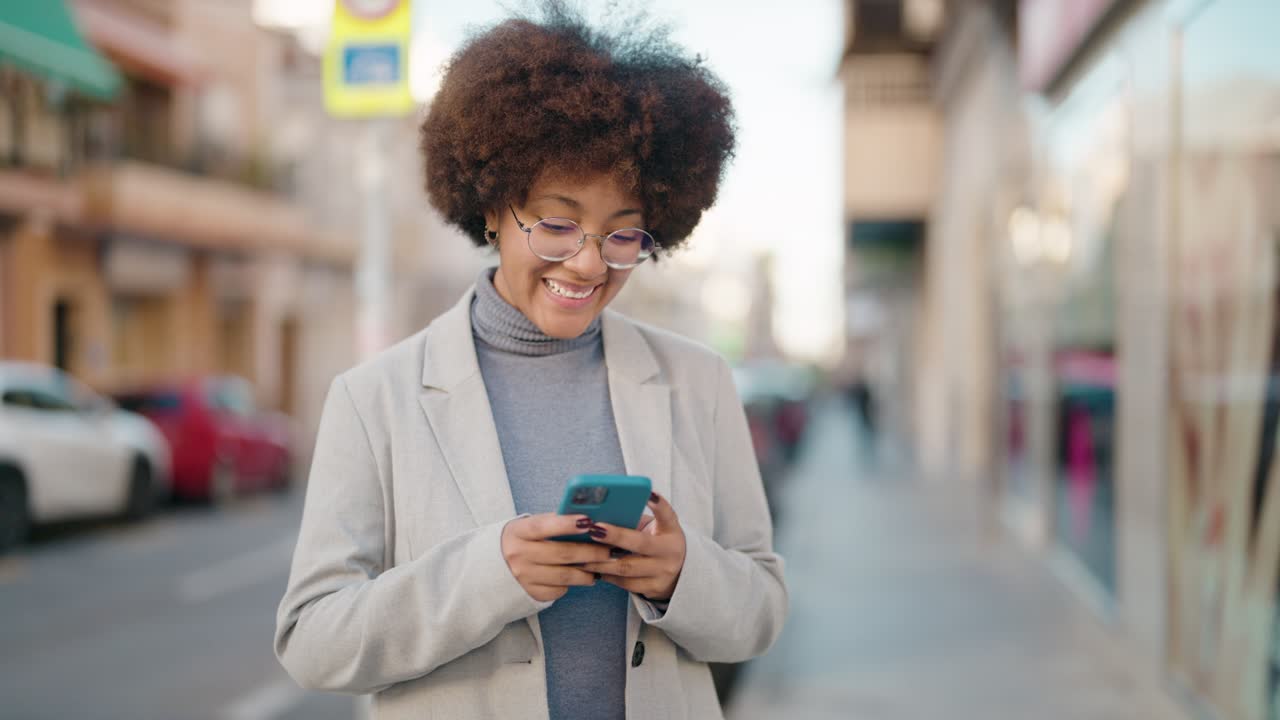 African american woman smiling confident using smartphone at street