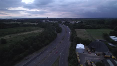 evening aerial drone footage over motorway in london, uk. urban traffic and cityscape at dusk