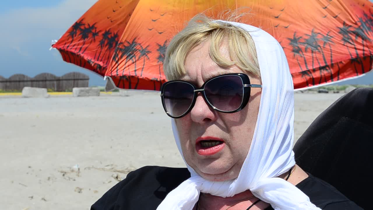 Riposo in spiaggia. Donna e ombrellone