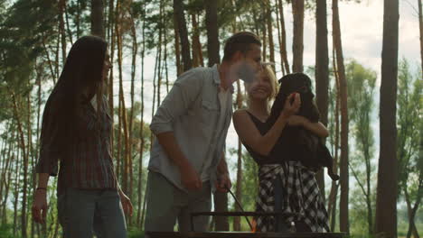 Smiling-woman-giving-man-strawberry-outdoors.-Friends-preparing-bbq-party