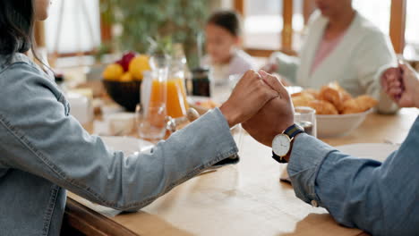 family, hands and praying over food in the dining