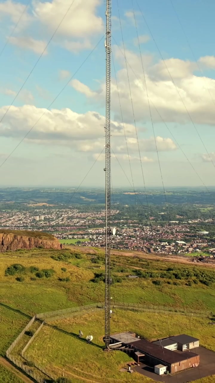 Video aéreo inverso lento de la Torre Transmisora de Televisión de Black Mountain en Belfast Occidental, Irlanda del Norte, en una tarde de verano, producido en 60 FPS, relación social 1080x1920 y con color Rec709.