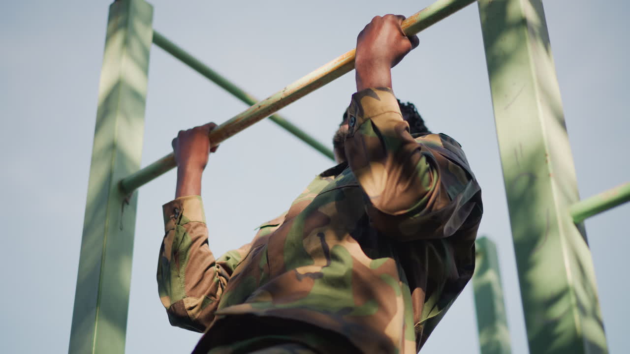 Military Man Trains On Obstacle Course, Camouflageclad Soldier Strengthens Grip During Workout, Resilient Military Personnel Pushes Strength And Endurance Through Intense Outdoor Training Session