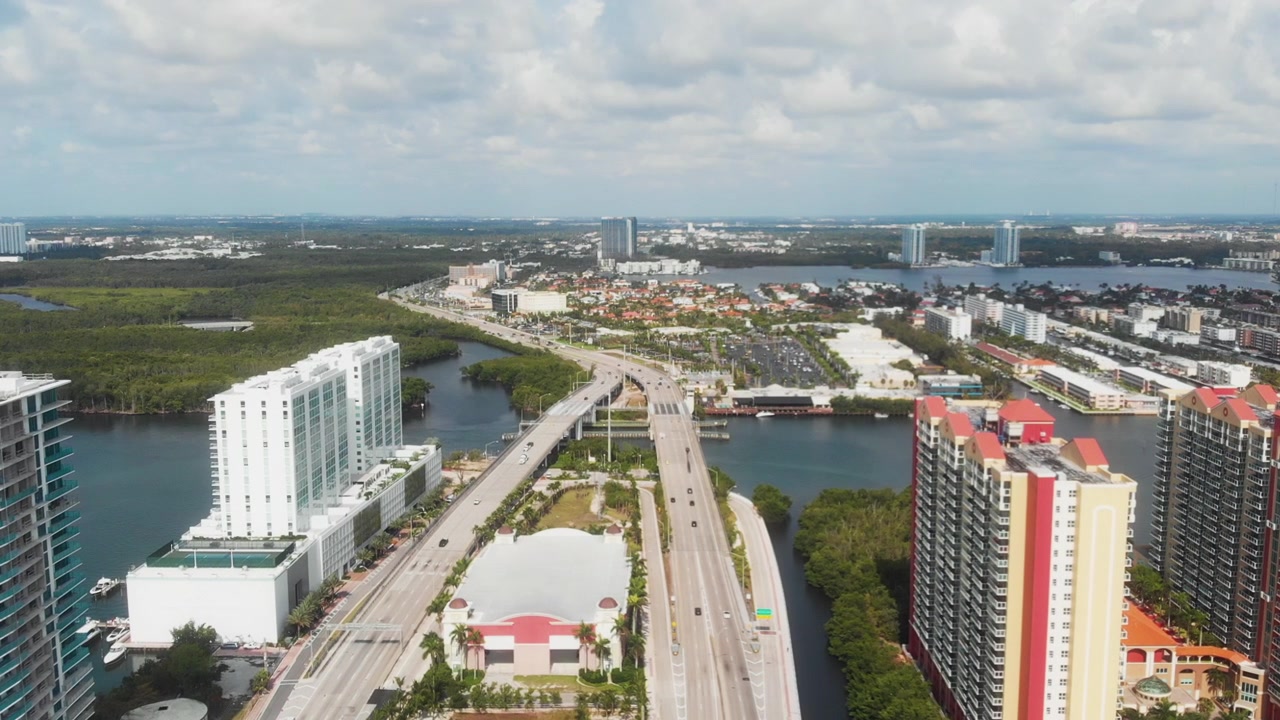Drone che avanza sopra le autostrade di Miami circondate dall'acqua e da grattacieli.