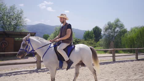 Reiter-Reitet-Auf-Seinem-Weißen-Pferd-Auf-Dem-Bauernhof.