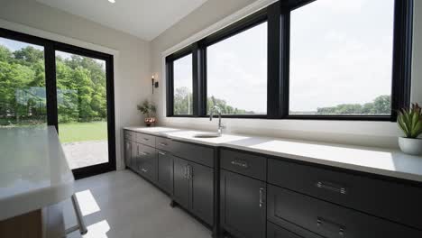 Wide-push-in-shot-of-a-basement-bar-with-white-countertops-and-abundant-natural-light