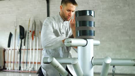 kung fu fighter practicing martial arts with wooden dummy 4k