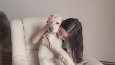 a pretty lady holds her labrador retriever