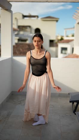 teenage ballerina practicing on a balcony