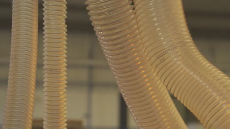 vista de cerca del conducto flexible para el extractor industrial que trabaja en una fábrica