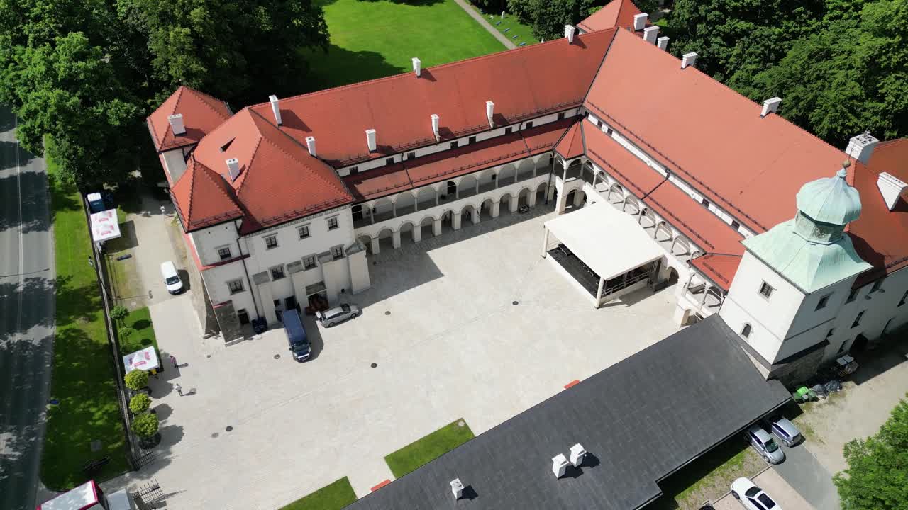 Flight over courtyyard of old castle in Sucha Beskidzka on sunny day - 4K palace