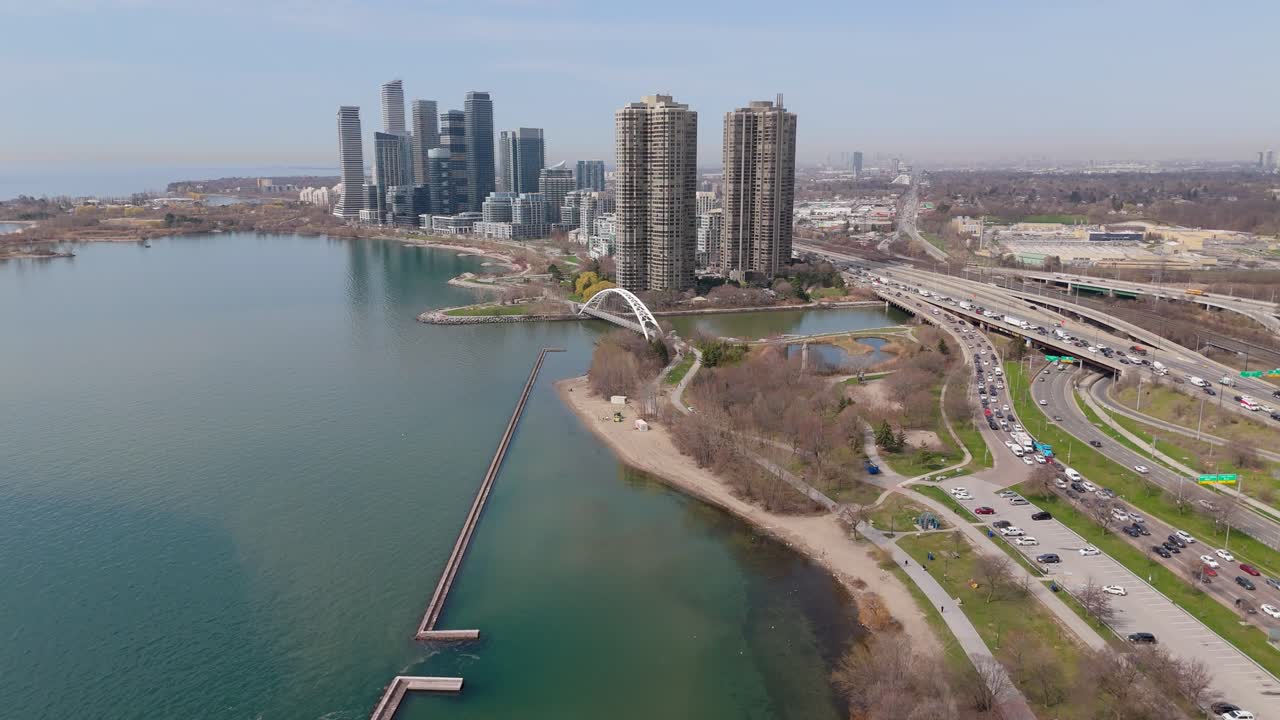 Drone establishing dolly of Parklawn condos, Humber Bay, Humber Bridge, and Lakeshore Blvd in Toronto, midday overcast sky