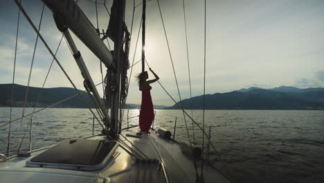 woman in red dress on a sailing yacht at sunset