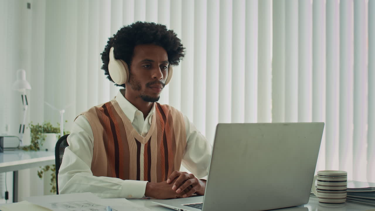 Black Entrepreneur Talking on Video Using Laptop at Office Desk