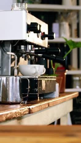 waiter serving coffee to customer at counter