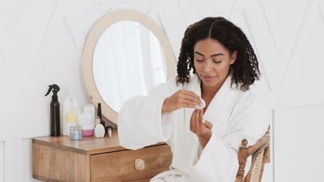 mujer aplicando esmalte de uñas en una vanidad