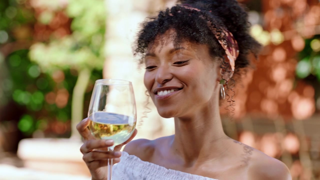 Happy Woman Laughing and Drinking White Wine Outdoors