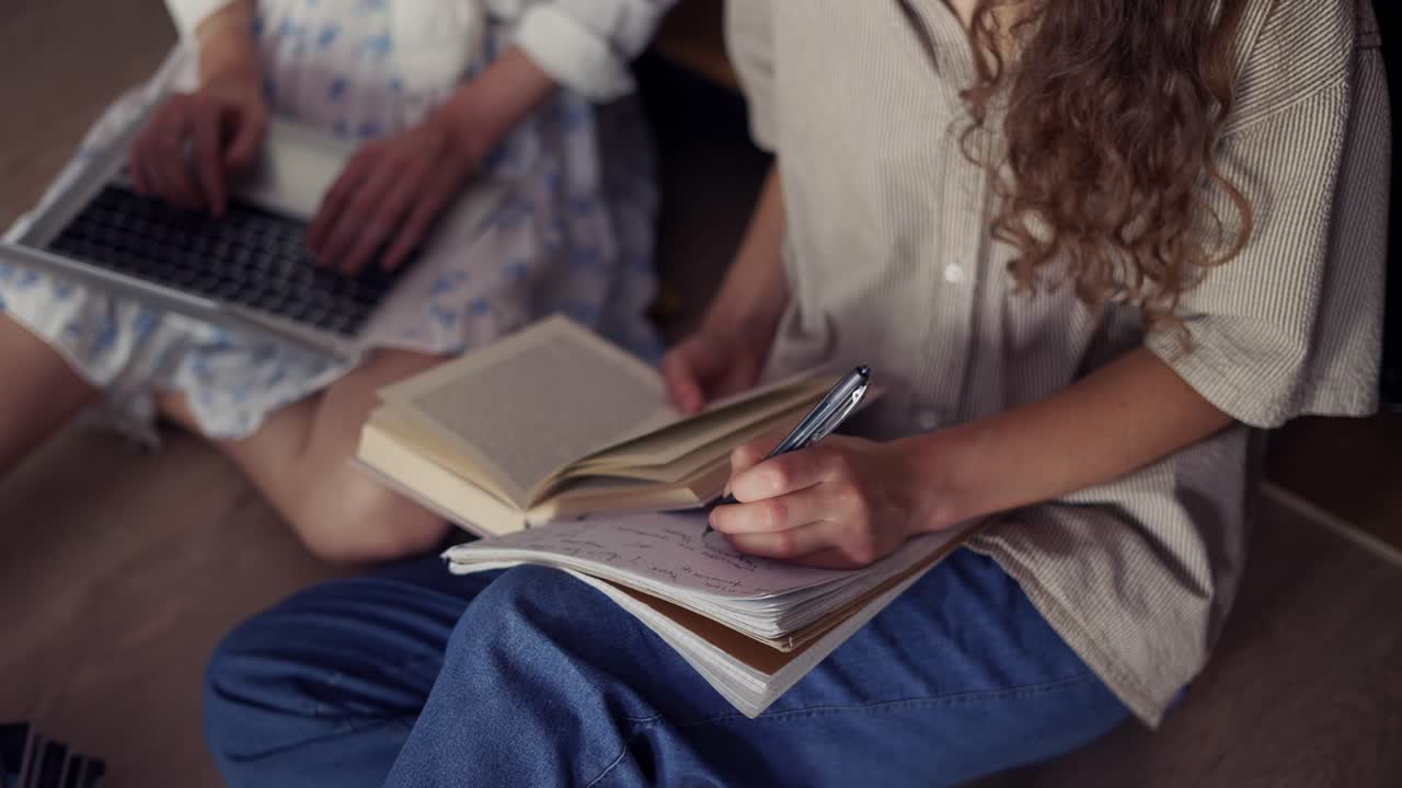 estudiantes femeninas aprendiendo juntas en la biblioteca de la universidad en el piso, ángulo alto