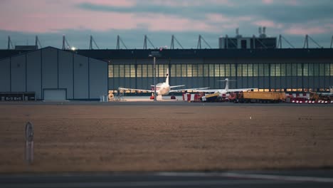 a passenger airplane is parked near the hangars in the vaclav havel airport, prague