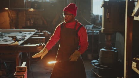 blacksmith shaping red-hot metal workpiece with sledgehammer on anvil