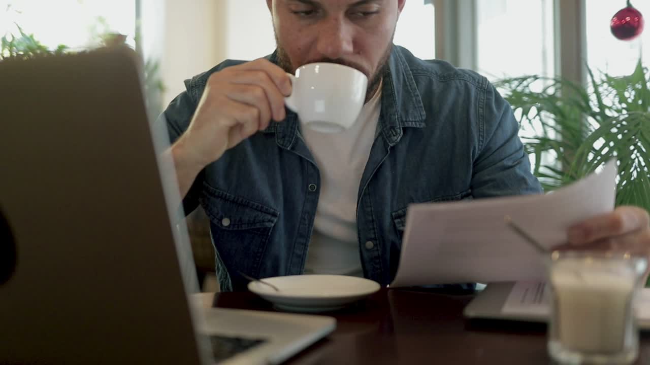 Freelancer drinking coffee and working in cafe
