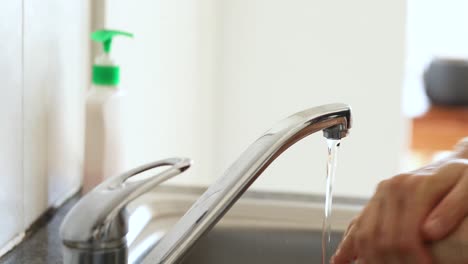 Caucasian-woman-washing-her-hands-with-soap-at-home