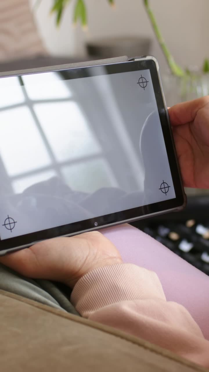 Vertical video: Noticing crosshair marks, woman in pink adjusting ...