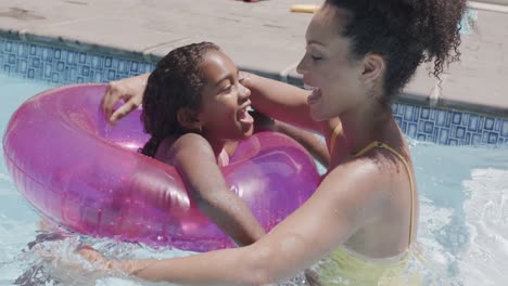 Portrait-of-happy-african-american-mother-and-daughter-embracing-in-swimming-pool,-slow-motion