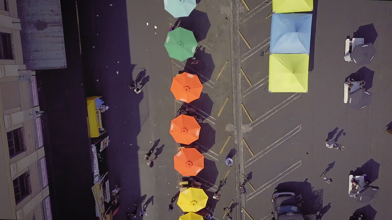 Aerial View of an Outdoor Market with Colorful Umbrellas and Tents