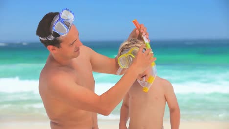 Padre-Ayudando-A-Su-Hijo-Con-Su-Snorkel