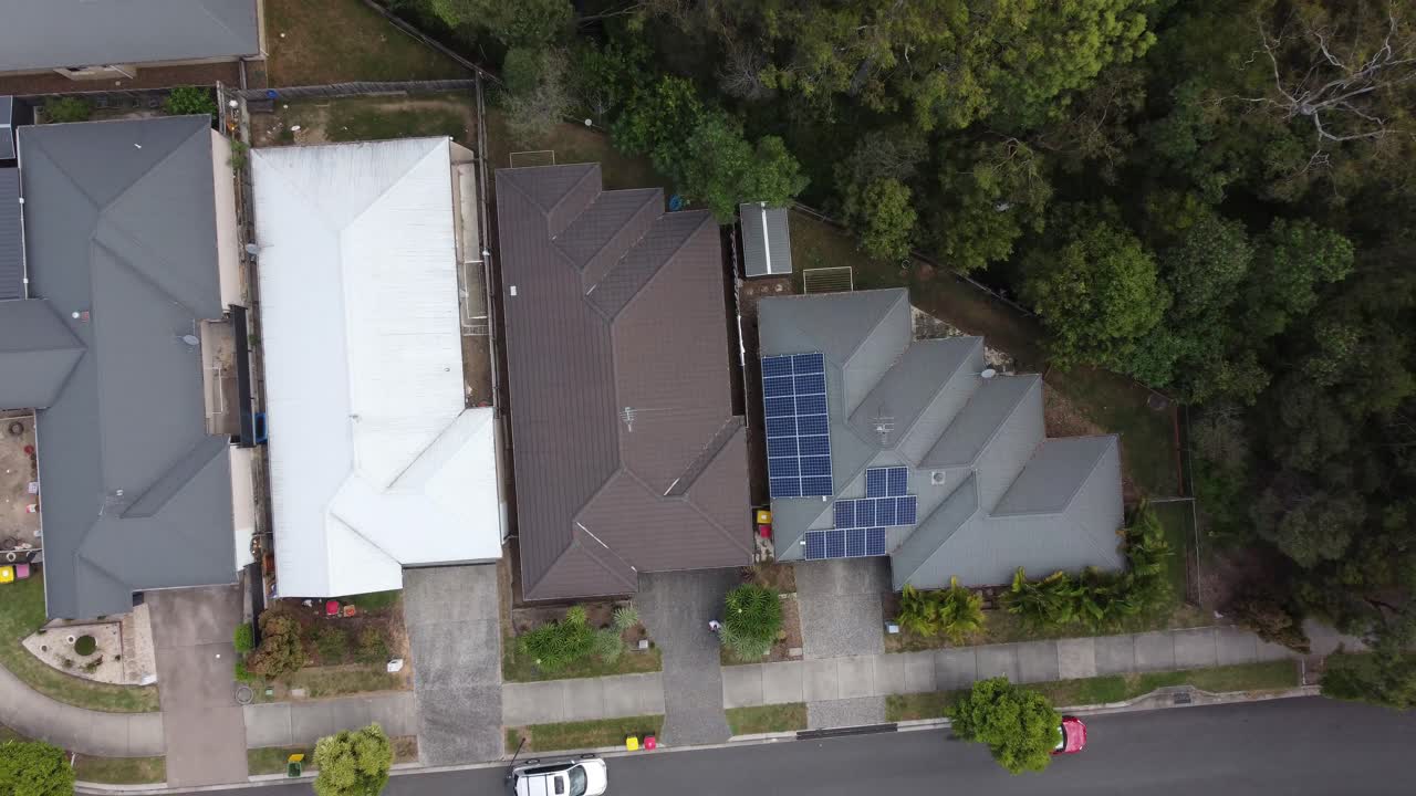 drone ascendiendo sobre casas privadas en un suburbio australiano revelando carreteras suburbanas y patios traseros