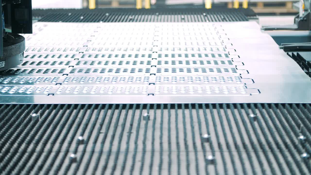 Metal perforating industrial equipment working on conveyor line