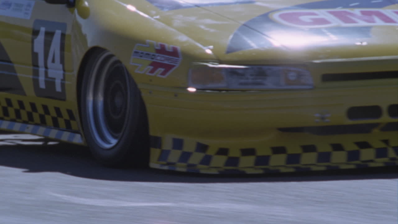 un auto de carreras amarillo conduce alrededor de una pista de carreras