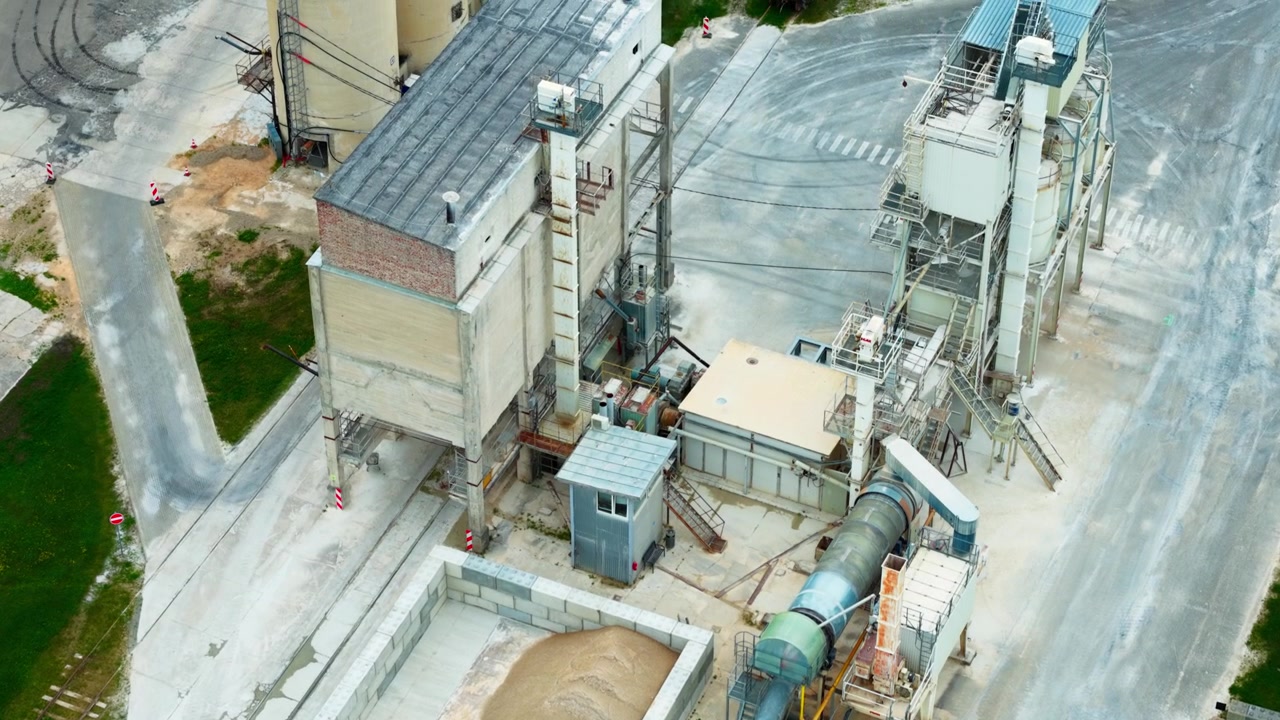 Medium tele aerial view of asphalt plant silos dryers and aggregate loading area