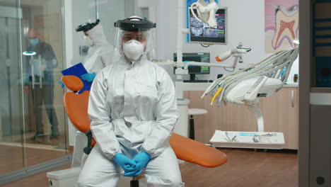 médico con traje de protección hablando en la cámara