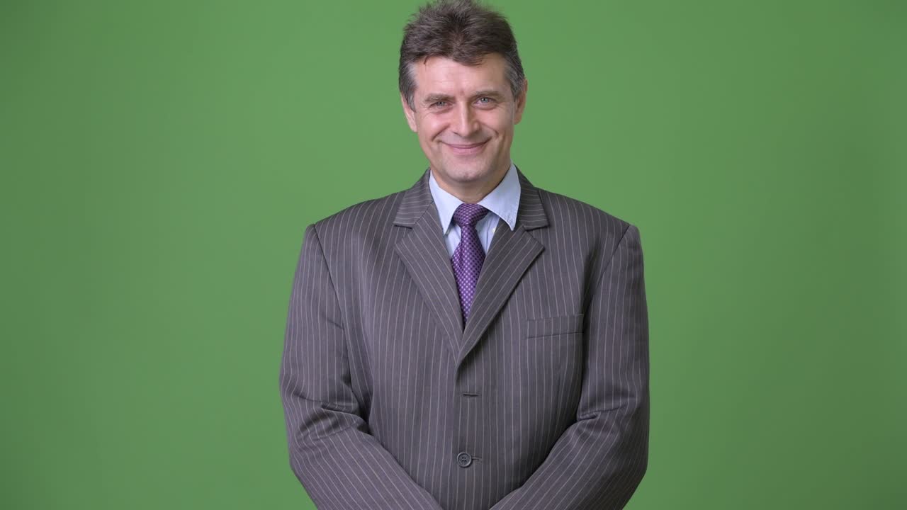 Uomo d'affari maturo e affascinante su sfondo verde