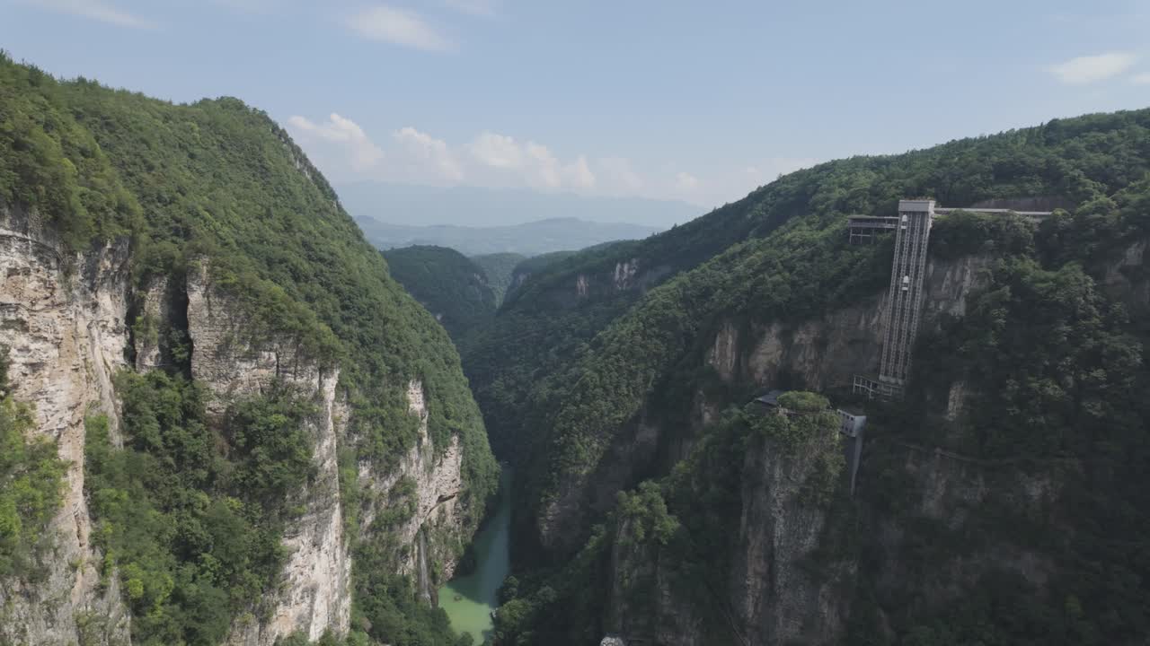Splendida ripresa aerea della straordinaria Zhangjiajie Grand Canyon, con lussureggianti montagne verdi e una struttura di ponte in vetro visibile. Perfetta per progetti di viaggio, natura o avventura.
