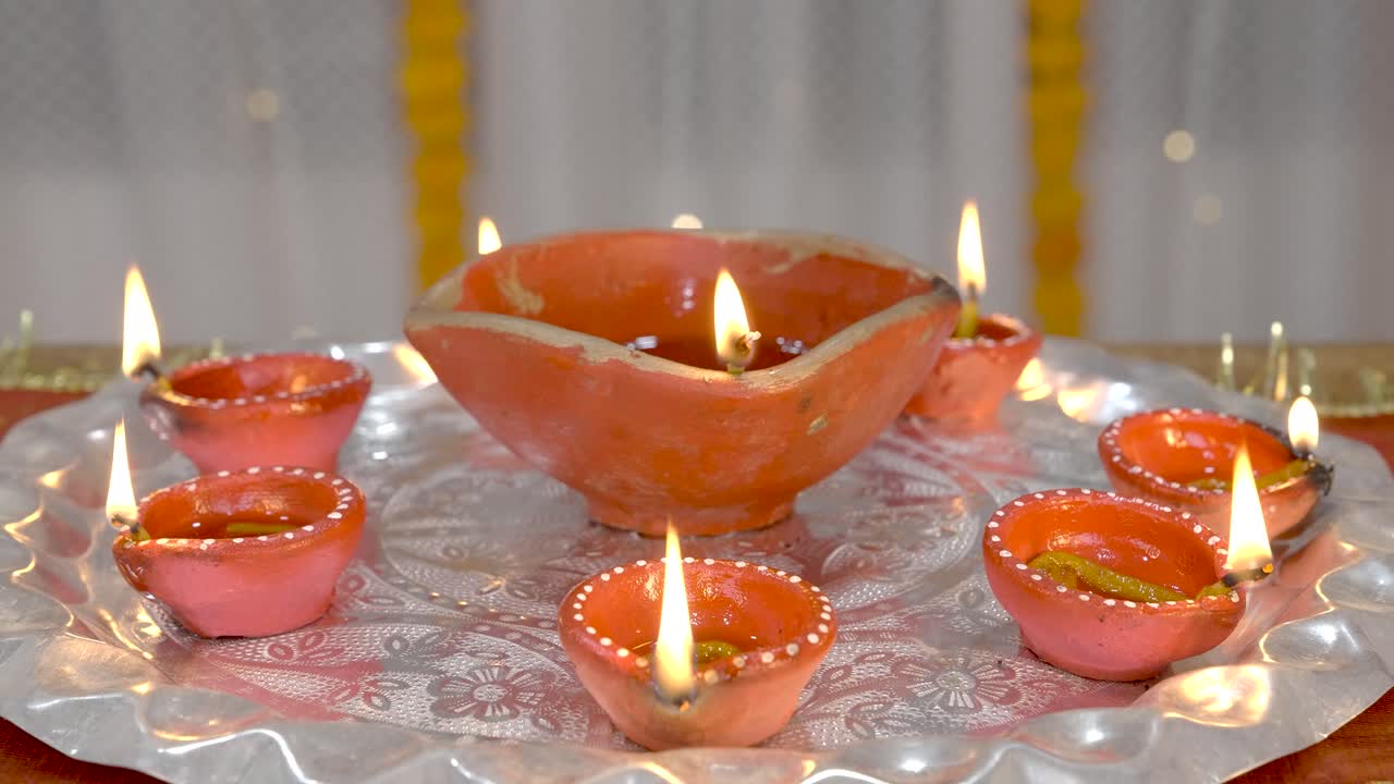 Diya accese o lampade di argilla decorate in un Thali.