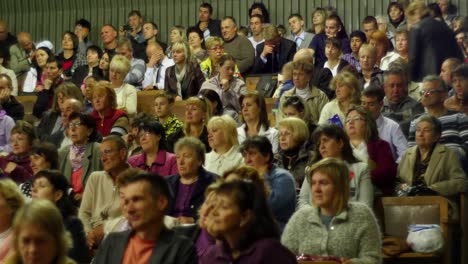 crowd of people to sitting and listening in a large hall
