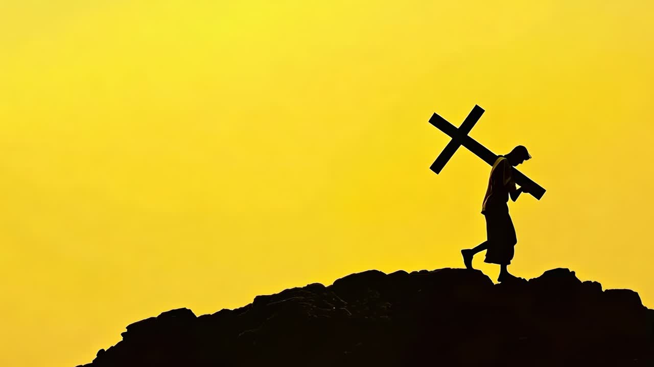 Silhouette of a person carrying a cross uphill against a vibrant yellow sky