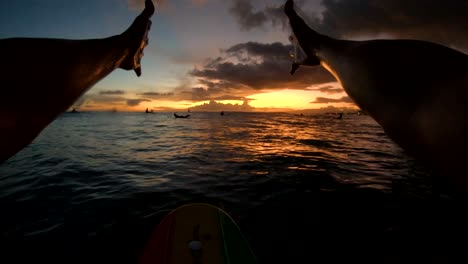 4k pov slow motion shot of some hands reaching towards the sunset while surfing at waikiki on oahu, hawaii